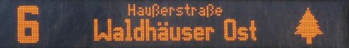 Ein elektronisches Anzeigeschild mit der Zahl 6 und den Worten "Haußerstraße Waldhäuser Ost", begleitet von einem Baum-Symbol.