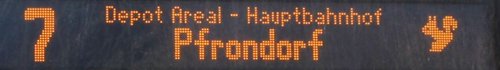 Ein digitales Anzeigeelement zeigt die Zahlen "7" und den Text "Depot Areal - Hauptbahnhof" sowie "Pfrondorf". Auf der rechten Seite ist ein Symbol eines Sektionszeichens abgebildet.